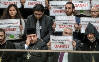 Mitglieder der Armenier-Initiative „Anerkennung Jetzt“ halten im Bundestag in Berlin Schilder mit dem Schriftzug „Danke“ hoch. © dpa / picture alliance / Michael Kappeler