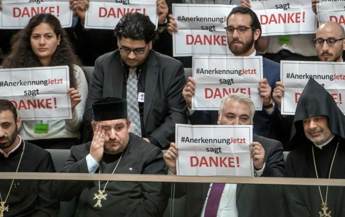 Mitglieder der Armenier-Initiative „Anerkennung Jetzt“ halten im Bundestag in Berlin Schilder mit dem Schriftzug „Danke“ hoch. © dpa / picture alliance / Michael Kappeler
