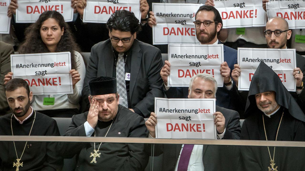 Mitglieder der Armenier-Initiative „Anerkennung Jetzt“ halten im Bundestag in Berlin Schilder mit dem Schriftzug „Danke“ hoch. © dpa / picture alliance / Michael Kappeler