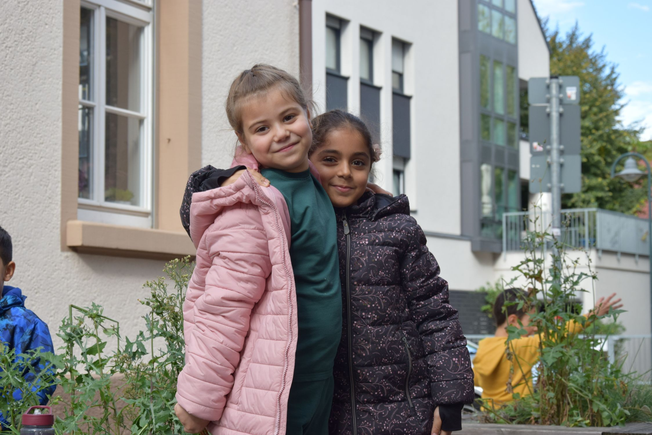 Zwei Kinder der Samstagsschule stehen gemeinsam im Freien